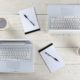 three laptops and a cup of coffee arranged on a wooden table, showcasing a workspace setup in Adobe InDesign CC
