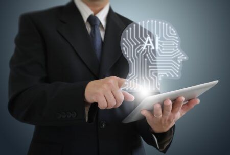 A man in a suit holds a tablet displaying a head, illustrating the concept of ai for presentations.