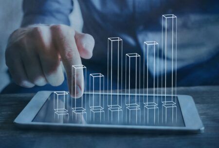 A businessman using a tablet to display graphs on the screen. Relevant to Capsim business simulation