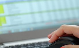 woman's hand with orange nail polish holding black computer mouse