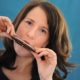 A woman learning how to play harmonica.