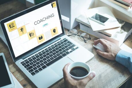 A man with his laptop taking the course on steps to launch an online coaching business.