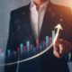 a businessman's hand points up on a graph, symbolizing business growth and a thought leadership strategy