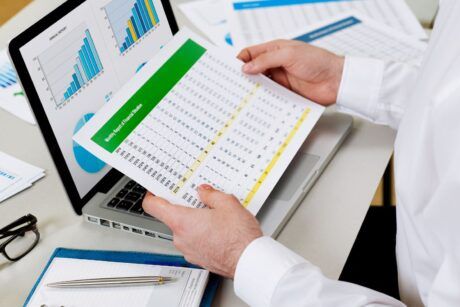 a man analyzes his personal financial statements with papers and a pen nearby, concentrating on his task