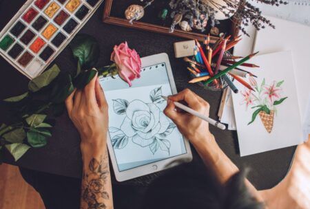an artist is engaged in drawing a flower on a tablet, utilizing Procreate Dreams to express her artistic vision