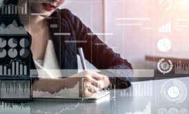 a woman in a business suit diligently writes on a laptop, engaged in a project management fundamentals course
