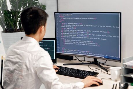 a man at a desk with a computer screen and keyboard, concentrating on a Tailwind CSS crash course
