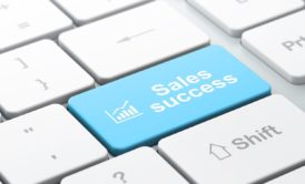 white keyboard with a blue key labeled sales success