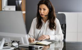 A woman in a headset sits at a desk, engaged in virtual assistant online training