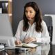 A woman in a headset sits at a desk, engaged in virtual assistant online training