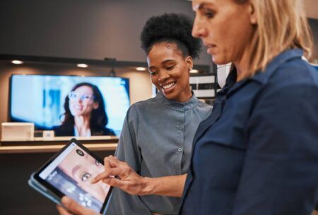Two women analyzing a tablet screen, focused on learning about what is digital advertising.
